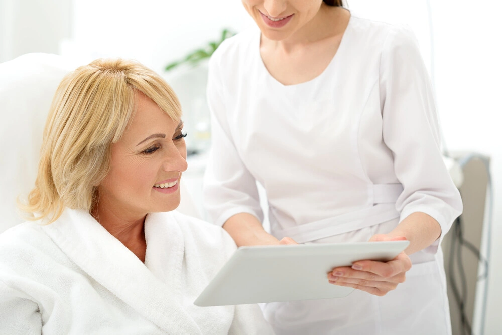 Skillful cosmetician consulting mature lady