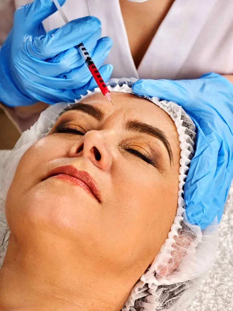 Filler injection female face. Plastic aesthetic facial surgery in beauty clinic. Elderly woman 50-60 years old is proud of her appearance