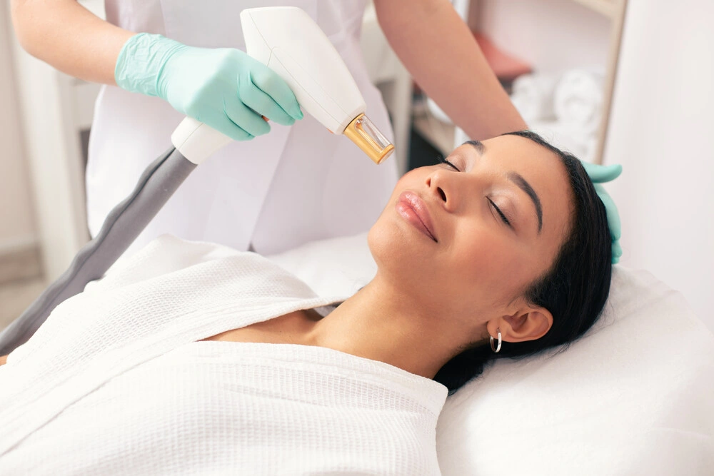 Close up of the pleased young woman lying with closed eyes and looking relaxed during the laser treatment