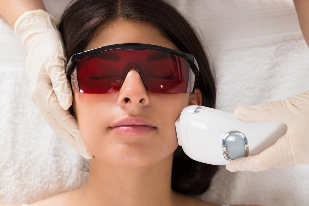 Close-up Of Beautician Giving Epilation Laser Treatment On Woman's Face