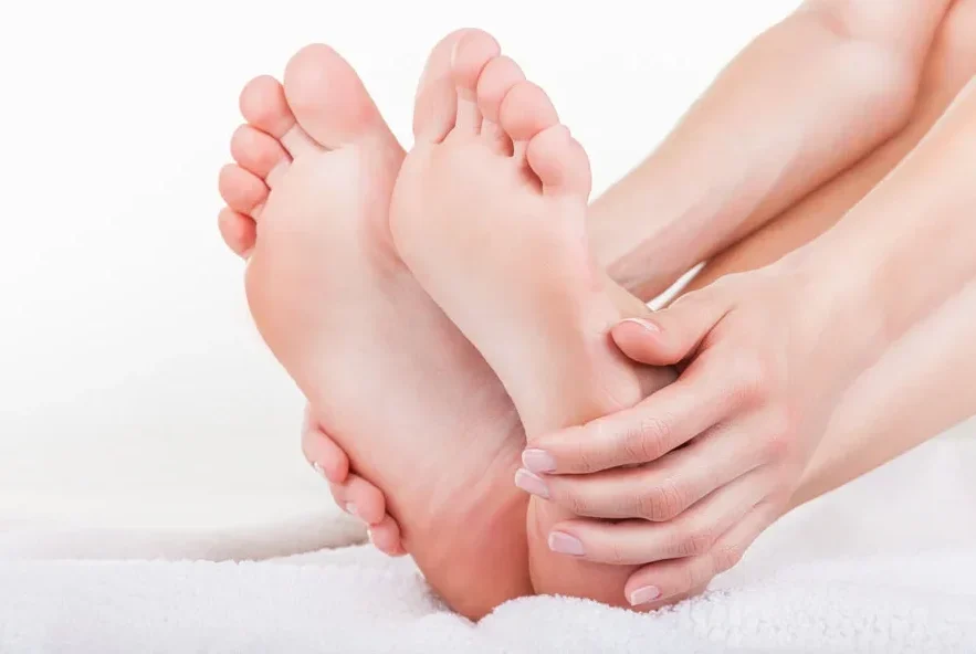 Beautiful female a foot and a heel on a white background